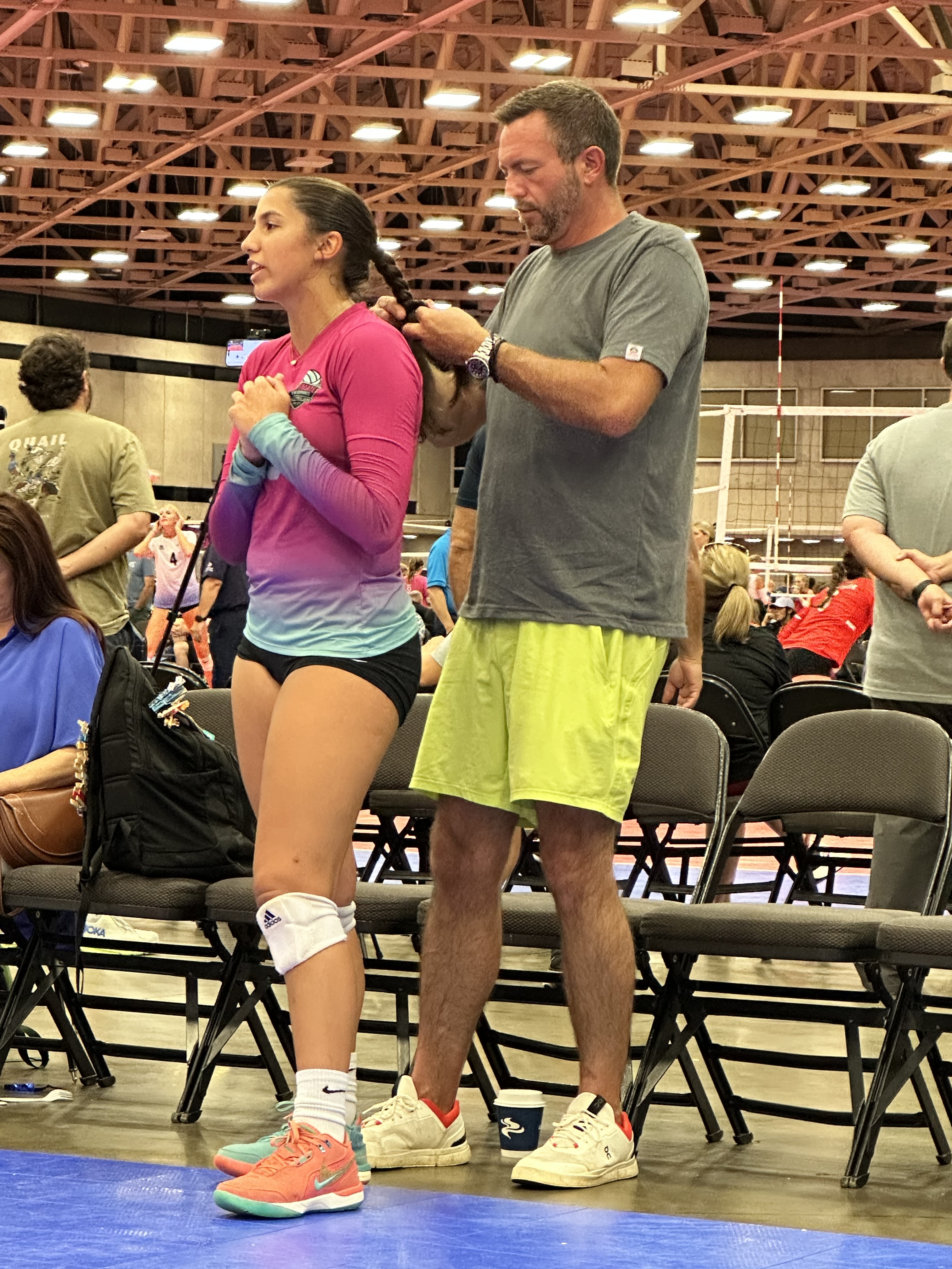 Image depicts a cartoon chick in a living room, wearing a vibrant green and orange Hawaiian shirt, sitting comfortably on ...